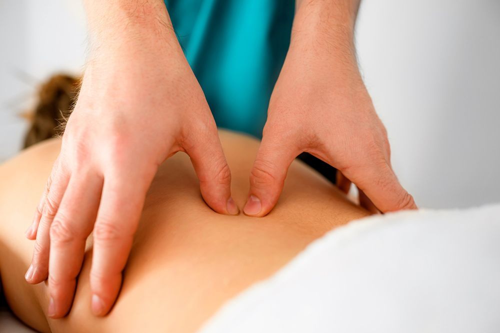 A man is giving a woman a massage on her back.