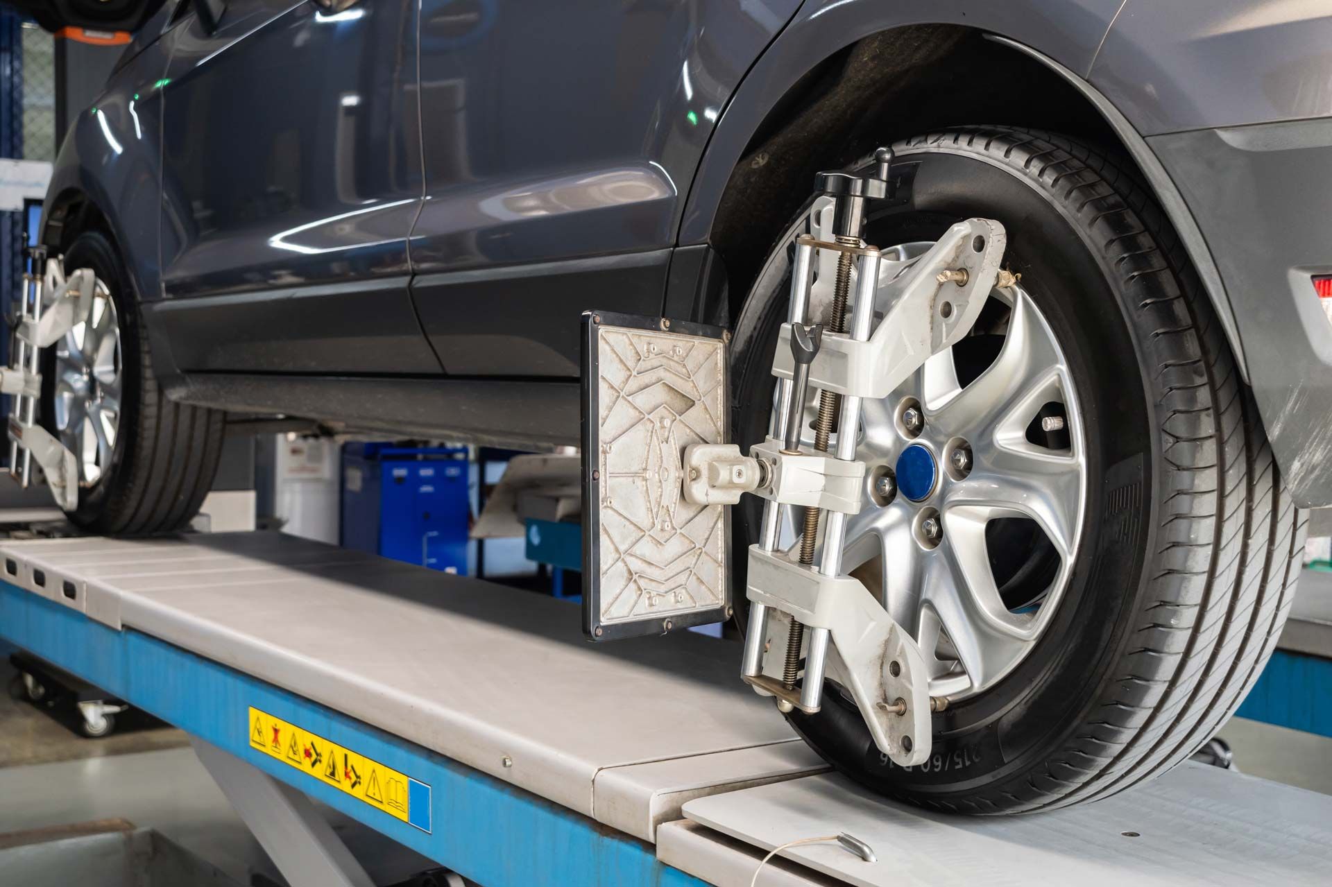 Car on a lift with alignment equipment attached to the wheels.