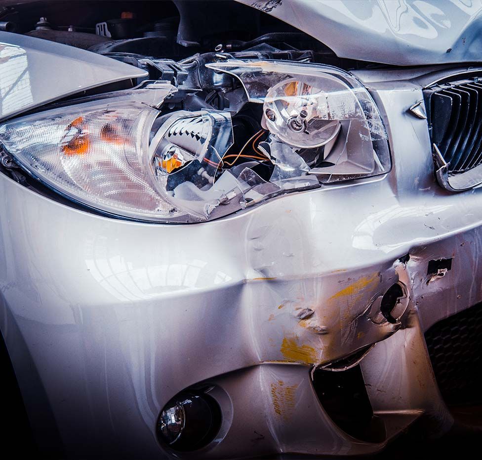 Damaged silver car, front-end collision.