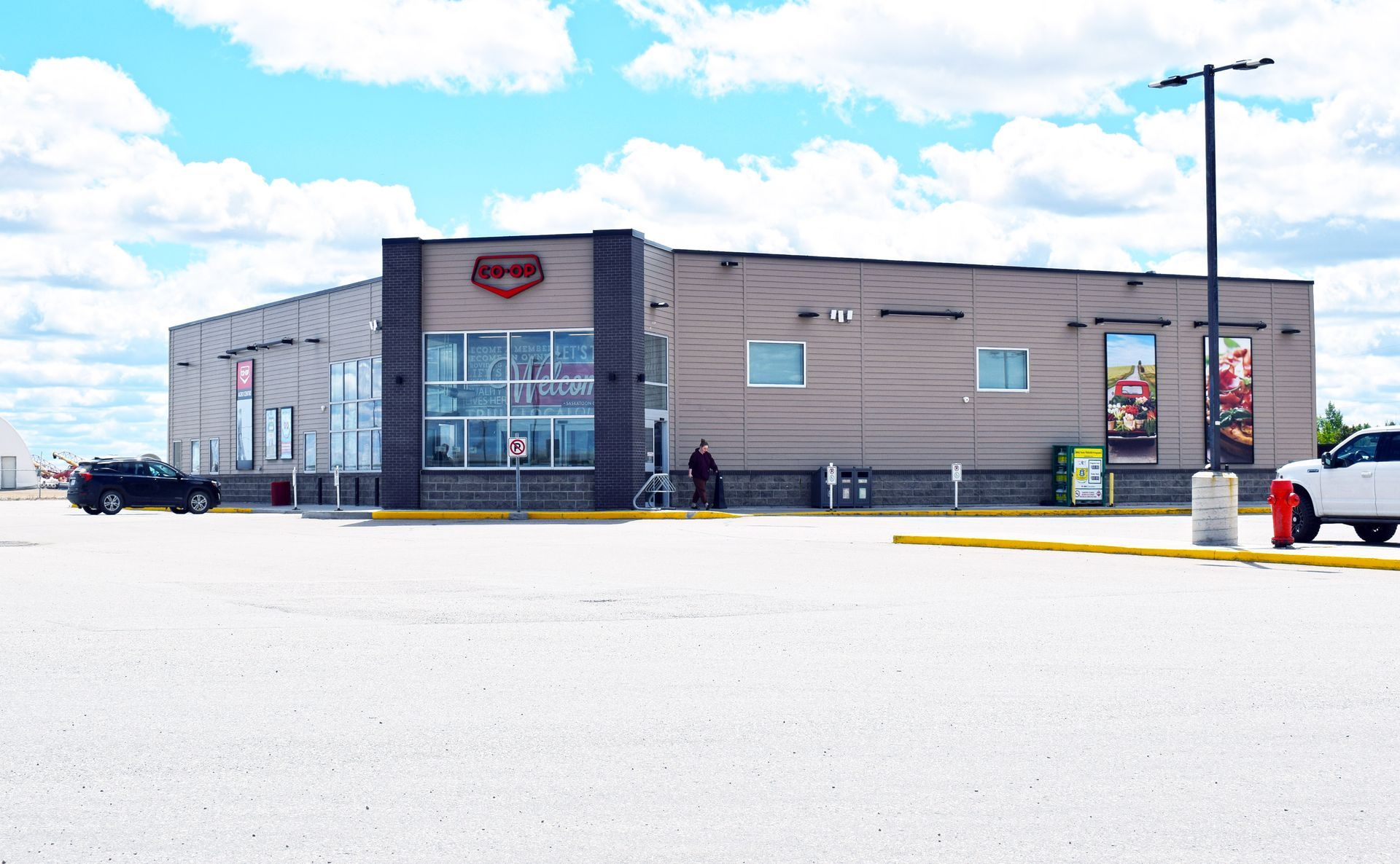 A white truck is parked in front of a large building
