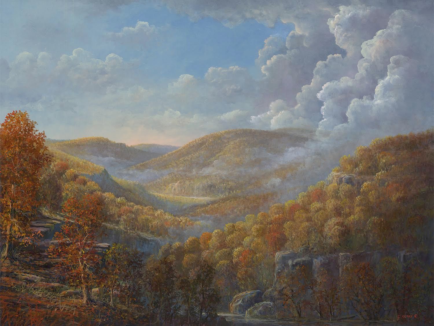 Autumn mountain valley landscape with cloudy sky, golden trees, and distant hills
