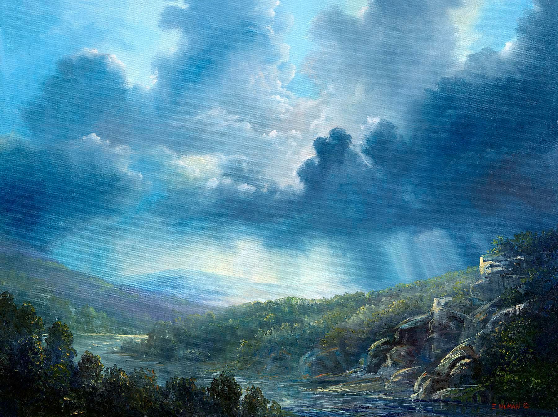 Blue storm clouds over a green mountain valley with sunlight breaking through and rain in the distance