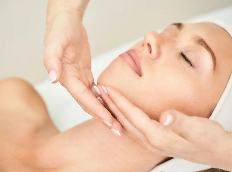 Lymphatic massage strokes along a client's jaw and neck