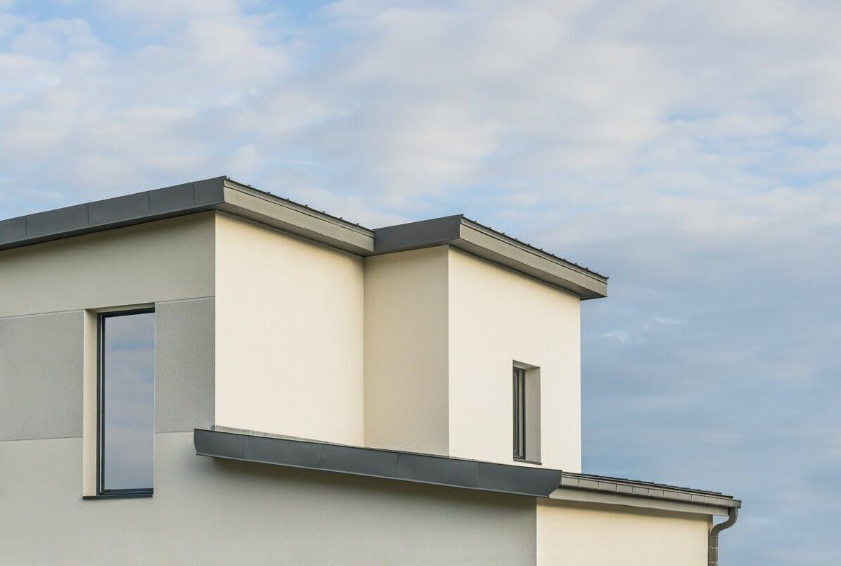 White modern building with dark gray trim under a blue sky.