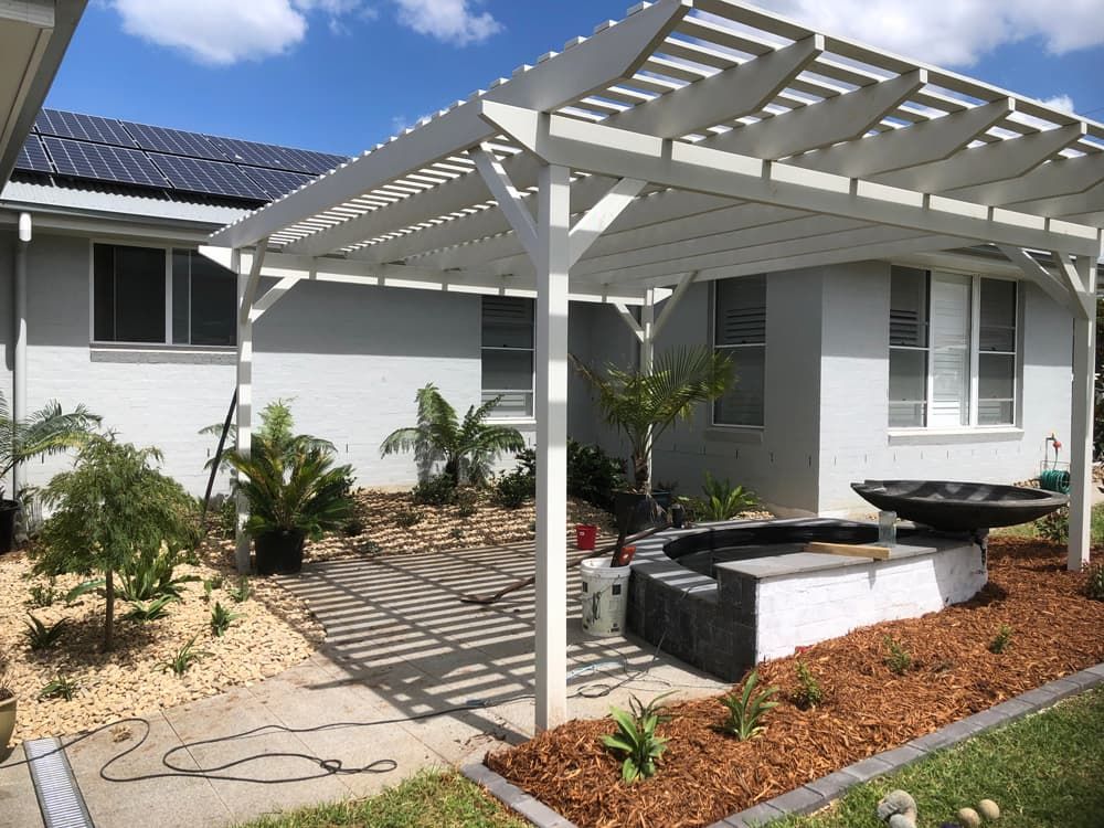 A White Pergola is Sitting in Front of a White House — Peter Phillips Landscape Design in Kiama, NSW