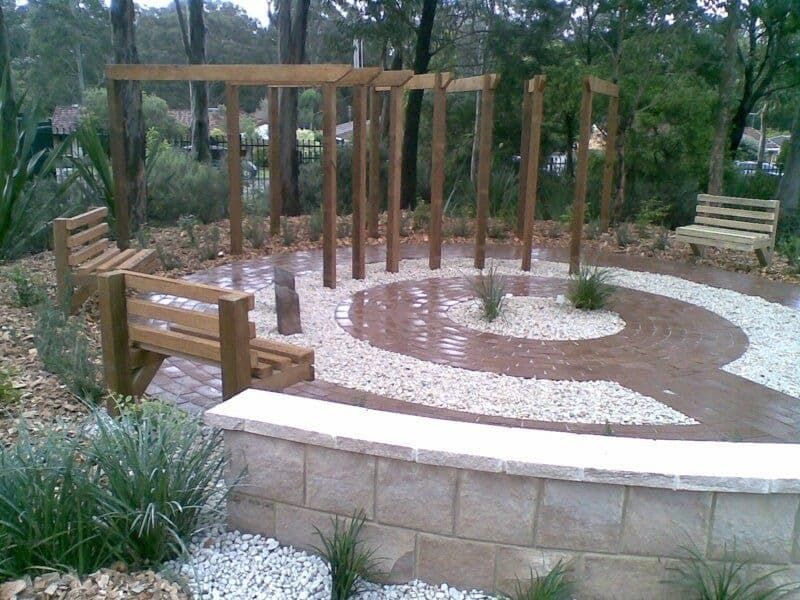 A Wooden Bench Sits in The Middle of A Garden — Peter Phillips Landscape Design in Kiama, NSW