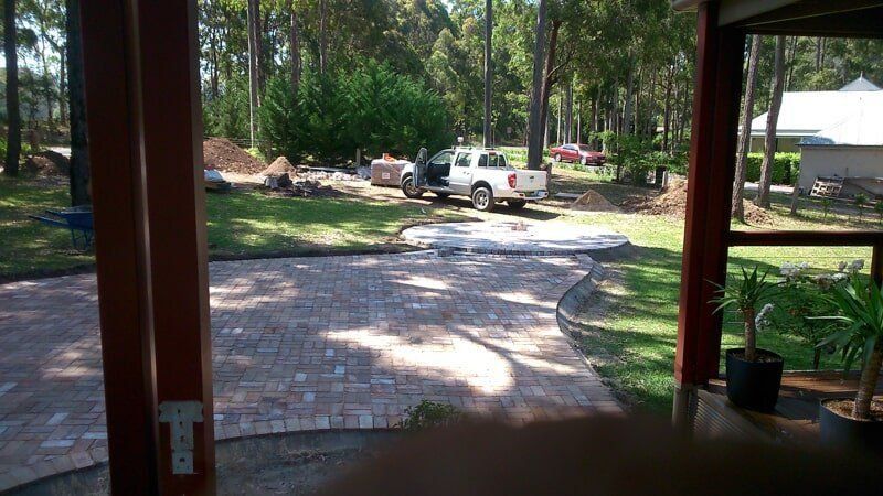 A White Truck Is Parked in The Backyard of A House — Peter Phillips Landscape Design in Bomaderry, NSW