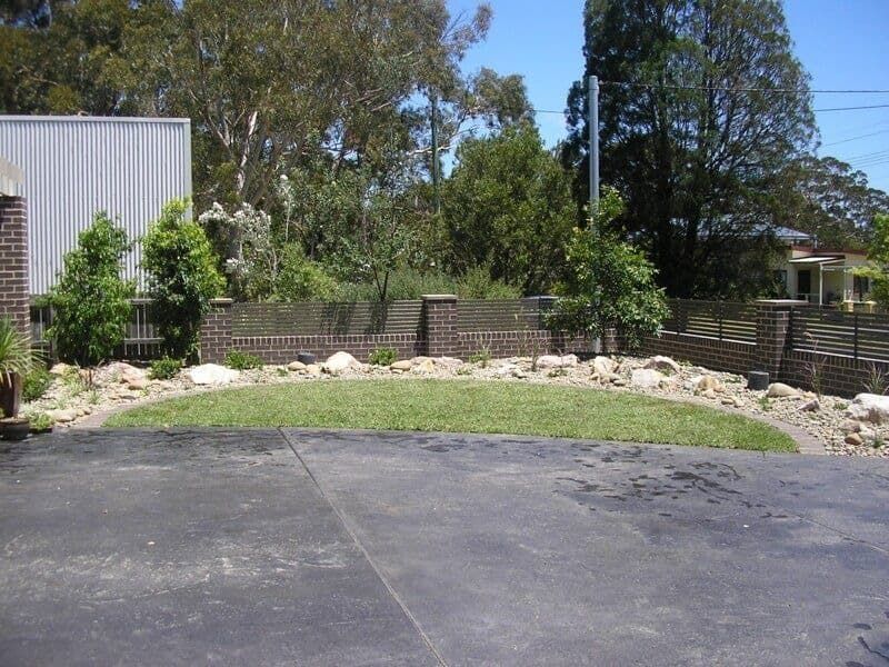 A Driveway Leading to A Lush Green Yard with Trees — Peter Phillips Landscape Design in Vincentia, NSW