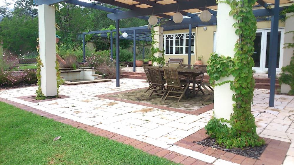 A Patio With a Table and Chairs Under a Pergola — Peter Phillips Landscape Design in Kiama, NSW
