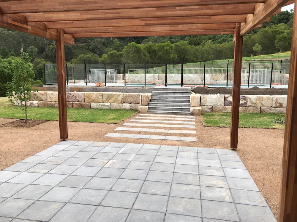 A Patio With a Pergola and Stairs Leading to a Pool — Peter Phillips Landscape Design in Bomaderry, NSW