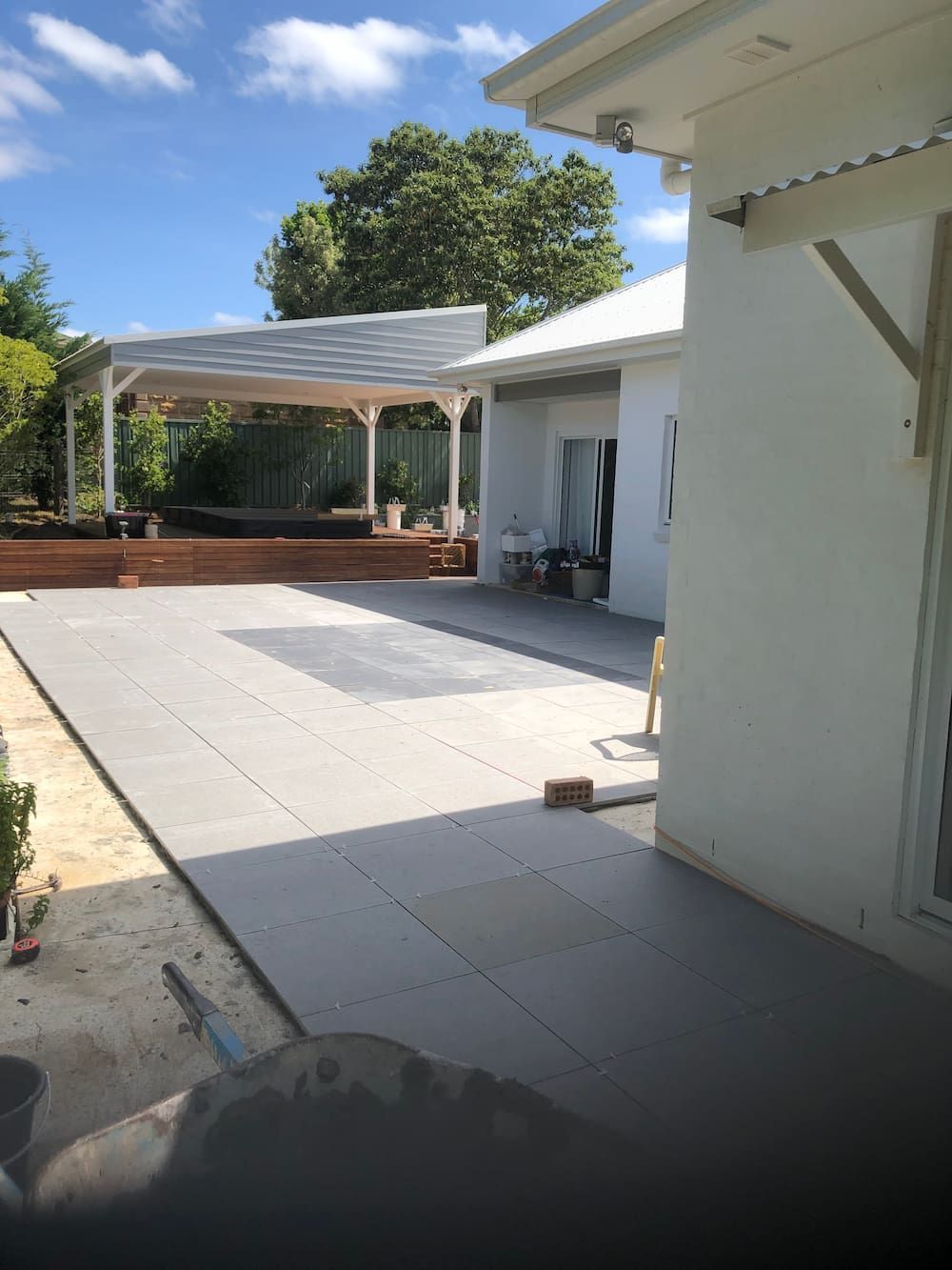 A White House With a Large Patio in Front of It — Peter Phillips Landscape Design in Bomaderry, NSW