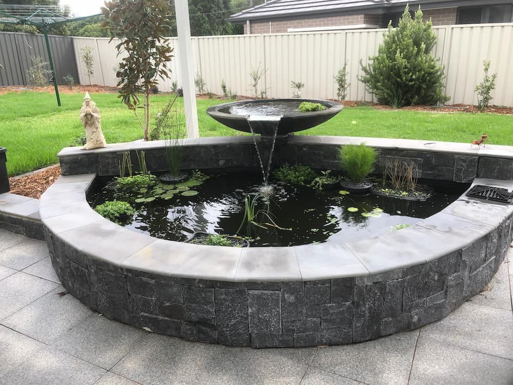 A Pond With a Fountain in the Middle of It — Peter Phillips Landscape Design in Bomaderry, NSW