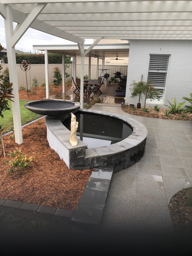 A White House With a Large Pond in Front of It — Peter Phillips Landscape Design in Bomaderry, NSW