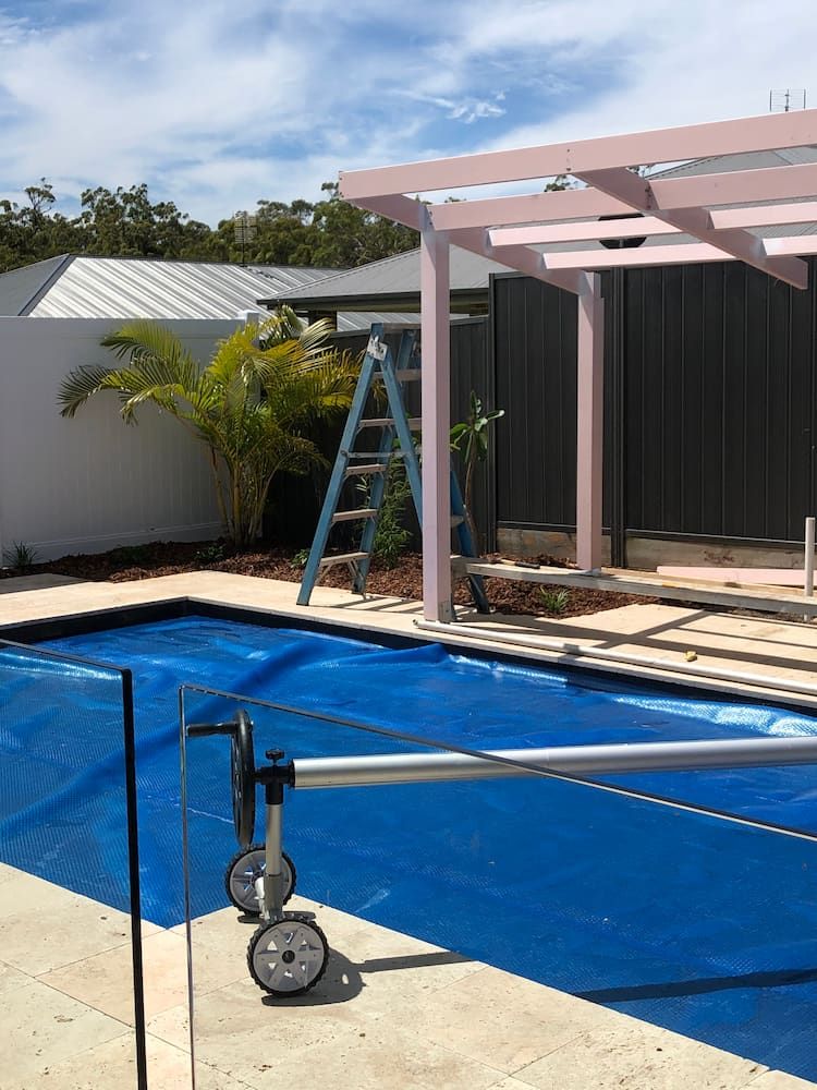 A Ladder is Sitting Next to a Swimming Pool — Peter Phillips Landscape Design in Bomaderry, NSW
