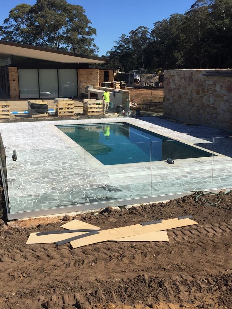 A Large Swimming Pool is Being Built in Front of a House — Peter Phillips Landscape Design in Bomaderry, NSW