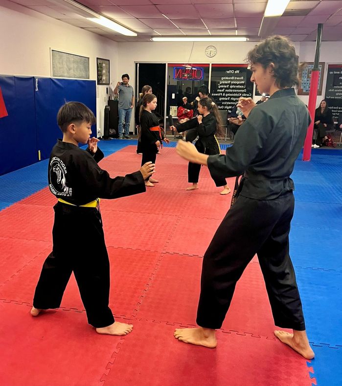 A group of people posing for a picture in a martial arts gym