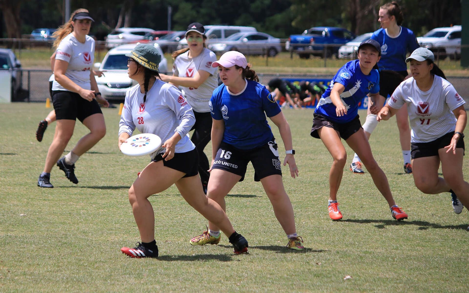 a group of women are playing frisbee on a field .