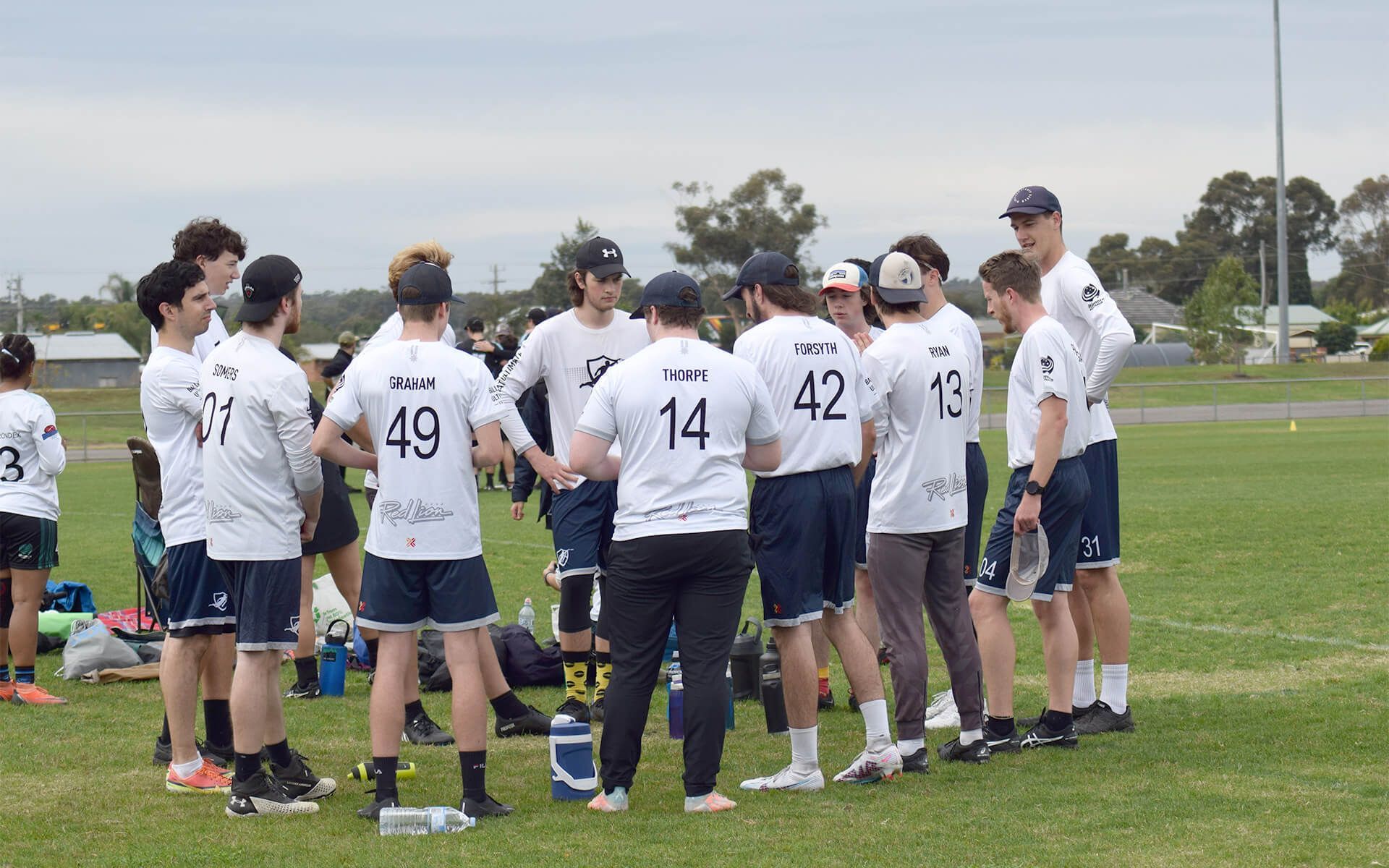 a group of soccer players are standing in a huddle on a field .