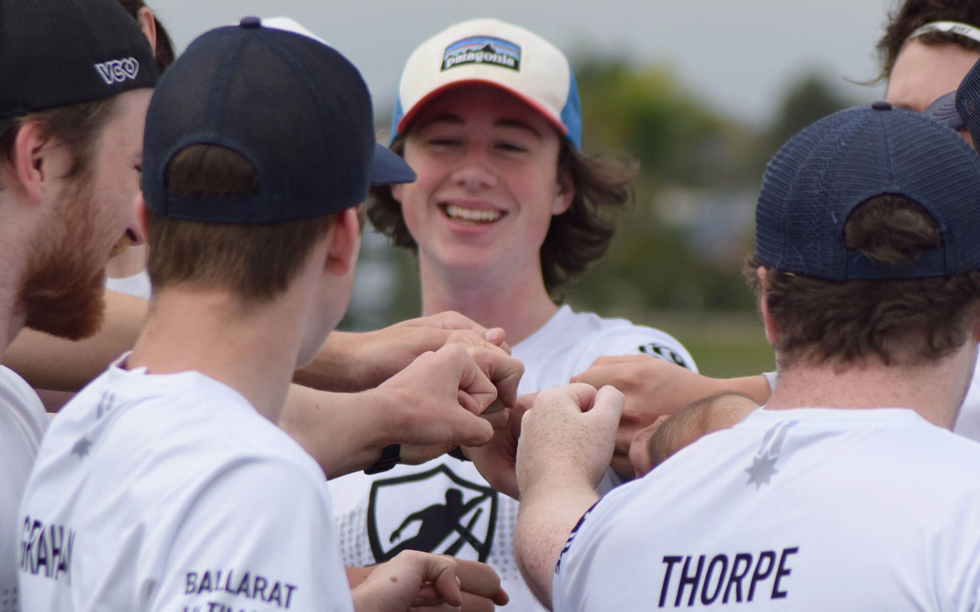 a group of young men are huddled together and one of them has the name thorpe on his back .
