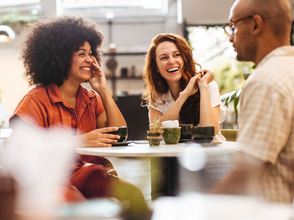 A group of people are sitting at a table in a restaurant talking to each other.