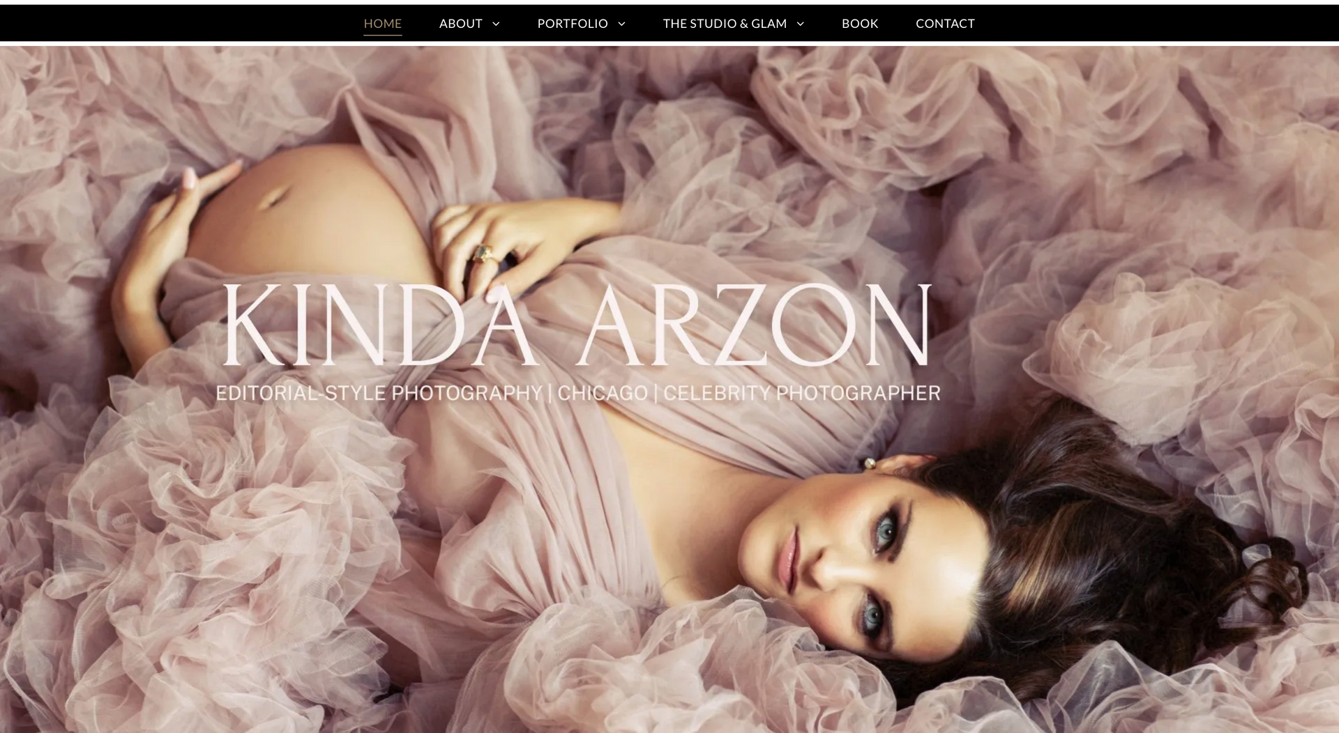 A pregnant woman is laying down in a pink dress.