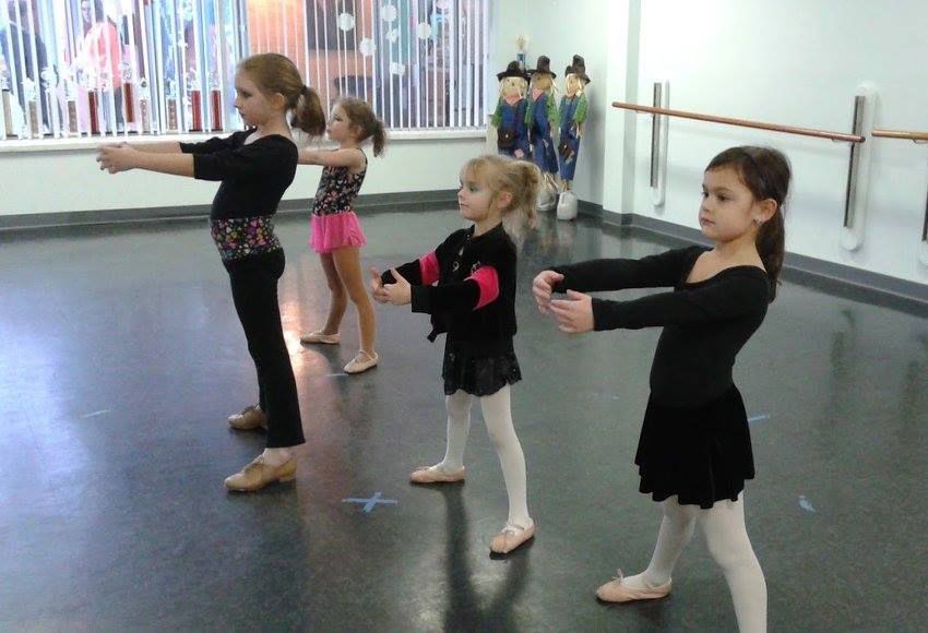 A group of young girls are dancing in a dance studio
