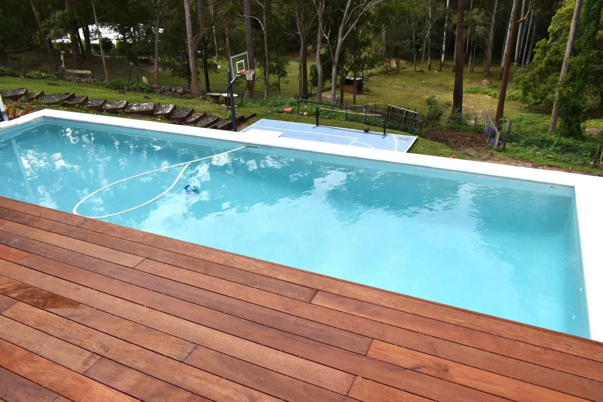 Rectangular Outdoor Pool Beside a Wooden Deck — Mad Pool Interiors and Renovations in Baringa, QLD