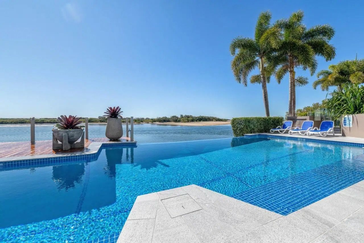 Infinity Pool Overlooking the Ocean With Palm Trees — Mad Pool Interiors and Renovations in Baringa, QLD