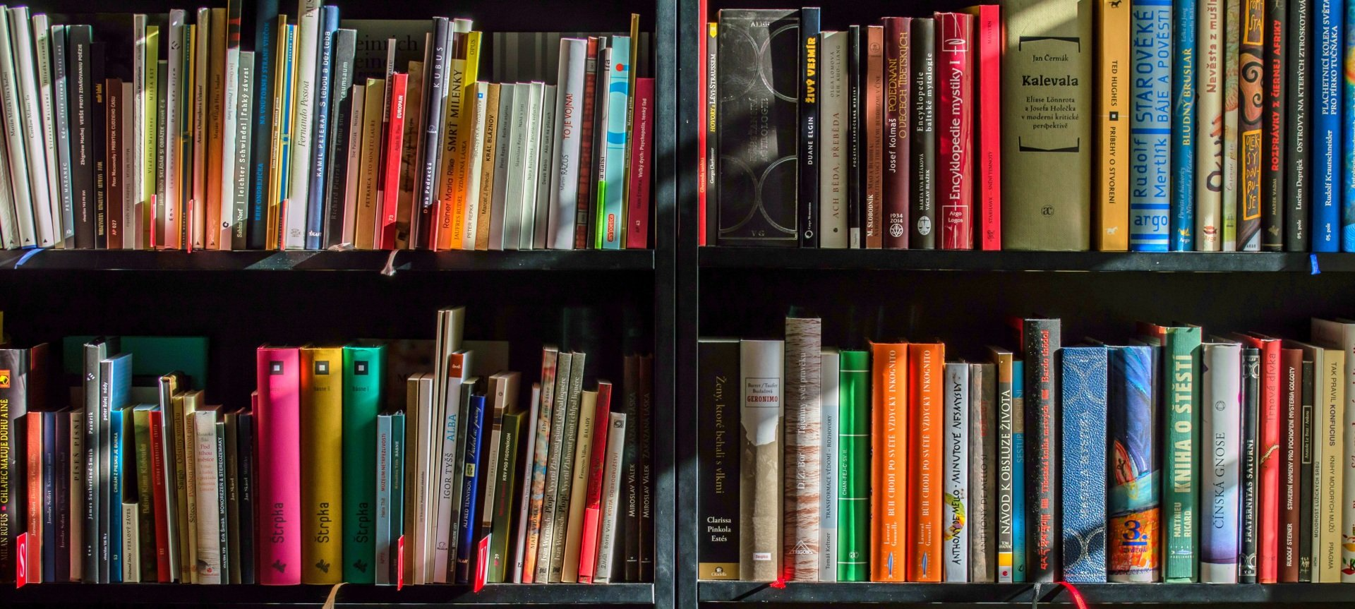 A bookshelf filled with lots of books in a library.