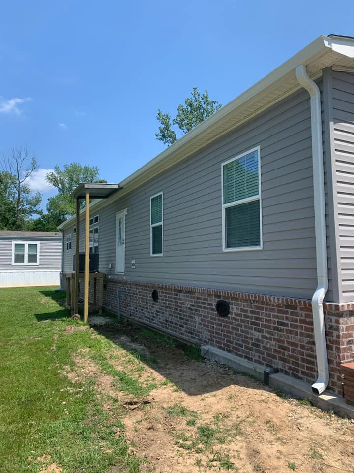 A mobile home with a gutter on the side of it.