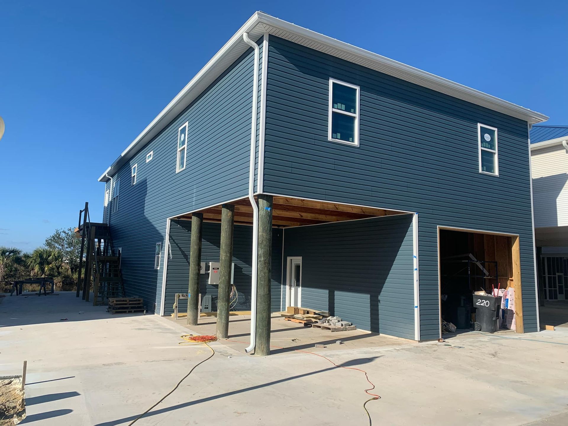 A large blue house with a garage underneath it