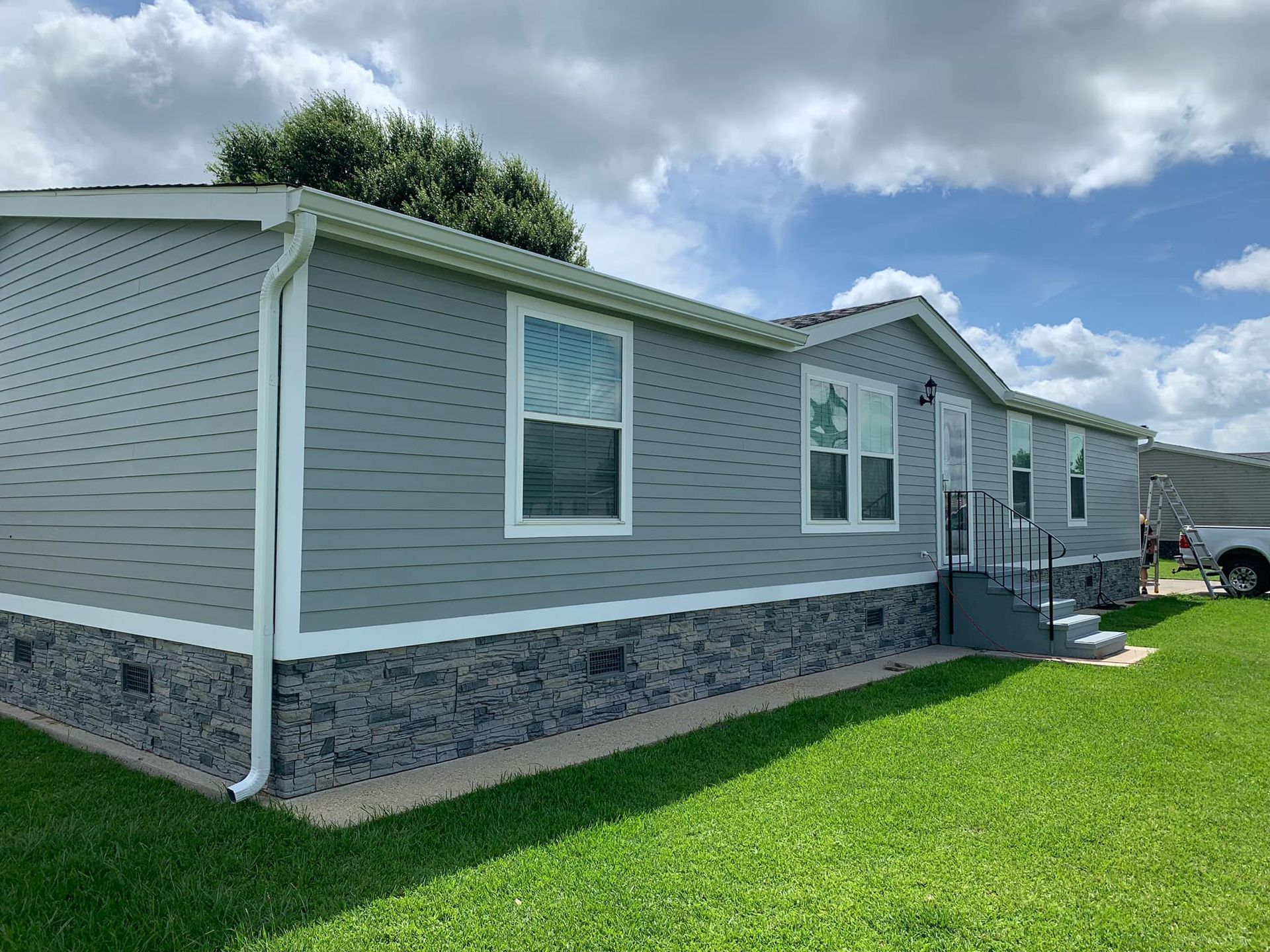 A mobile home is sitting on top of a lush green field.
