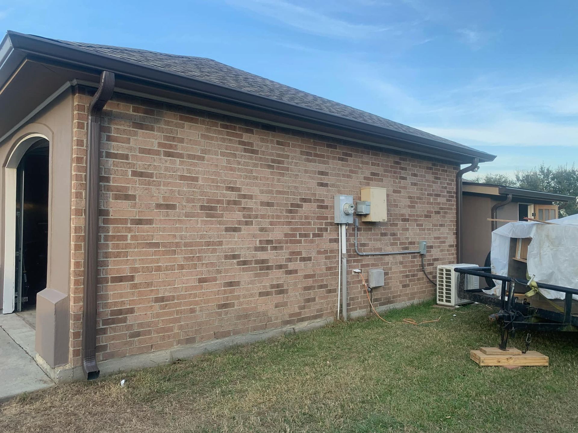 A brick house with a trailer parked in front of it.
