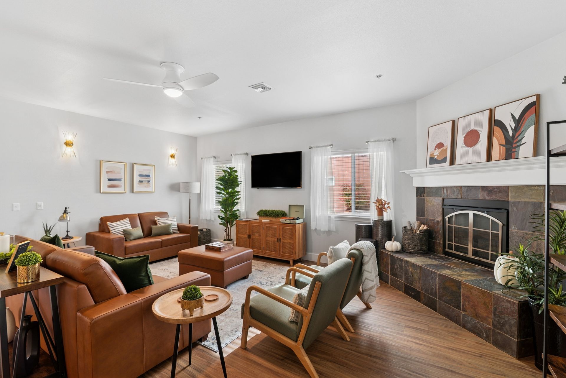 Living room with brown leather sofas, fireplace, TV, and wood furniture.