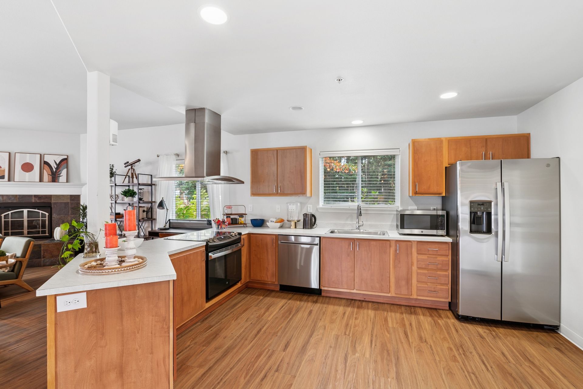 Bright kitchen with wood cabinets, stainless steel appliances, and a window.