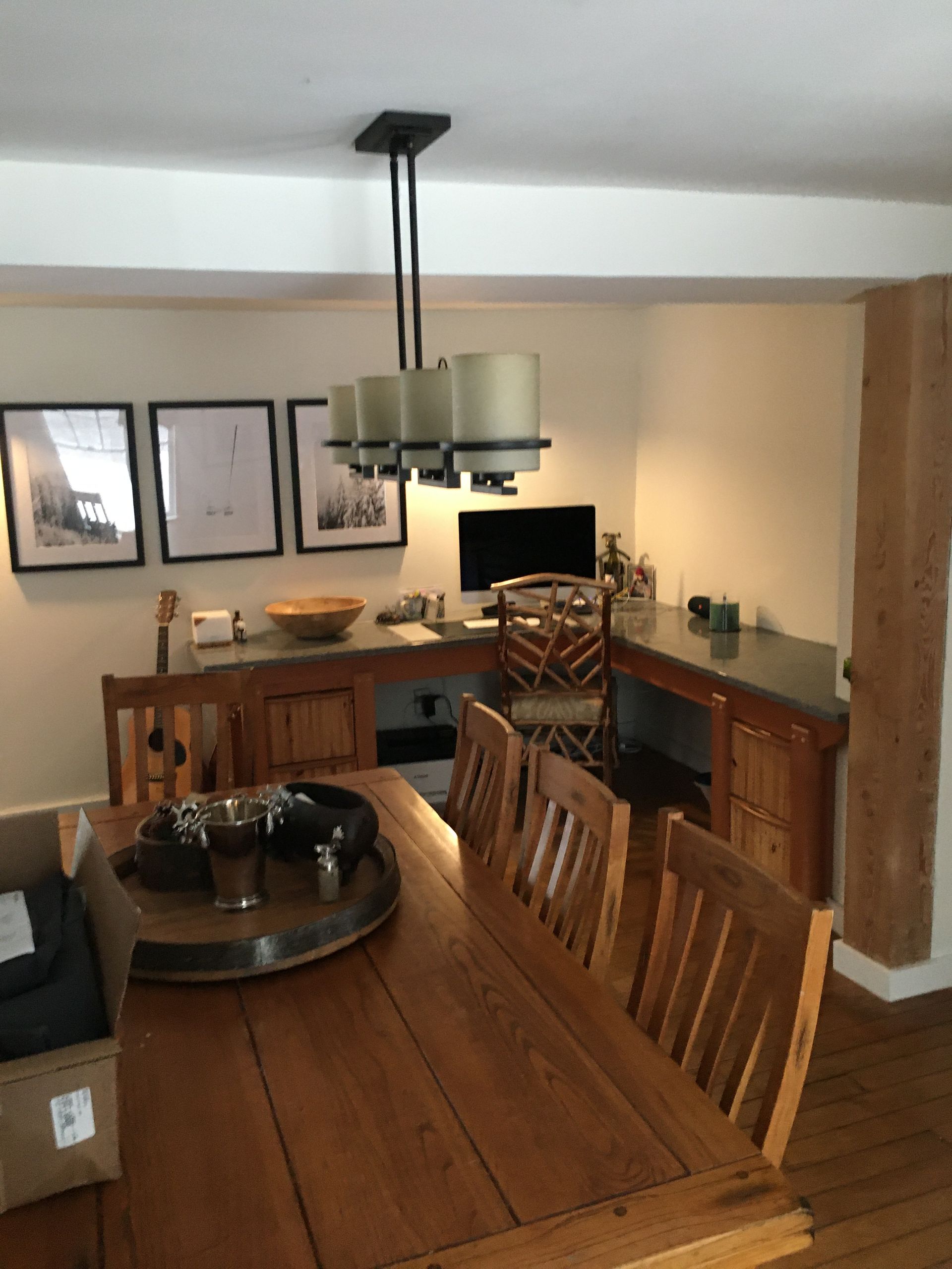 Dining room with wooden table and chairs, sideboard, framed wall art, and hanging light fixture
