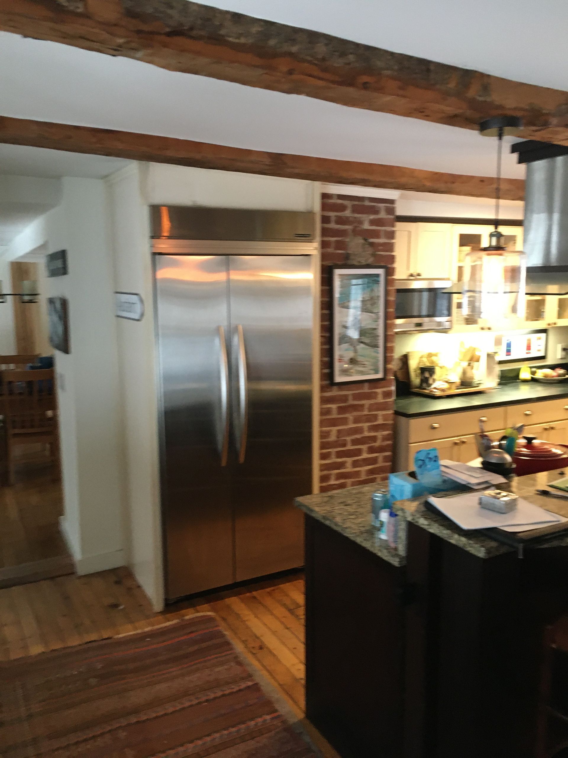 Kitchen with stainless steel refrigerator, exposed wooden beams, and island countertop