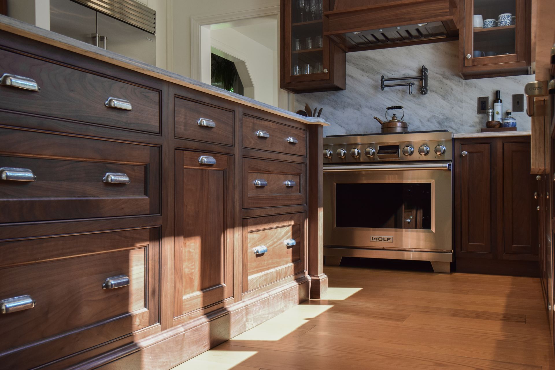 White kitchen with built-in stainless steel refrigerator, cabinets, and black countertop
