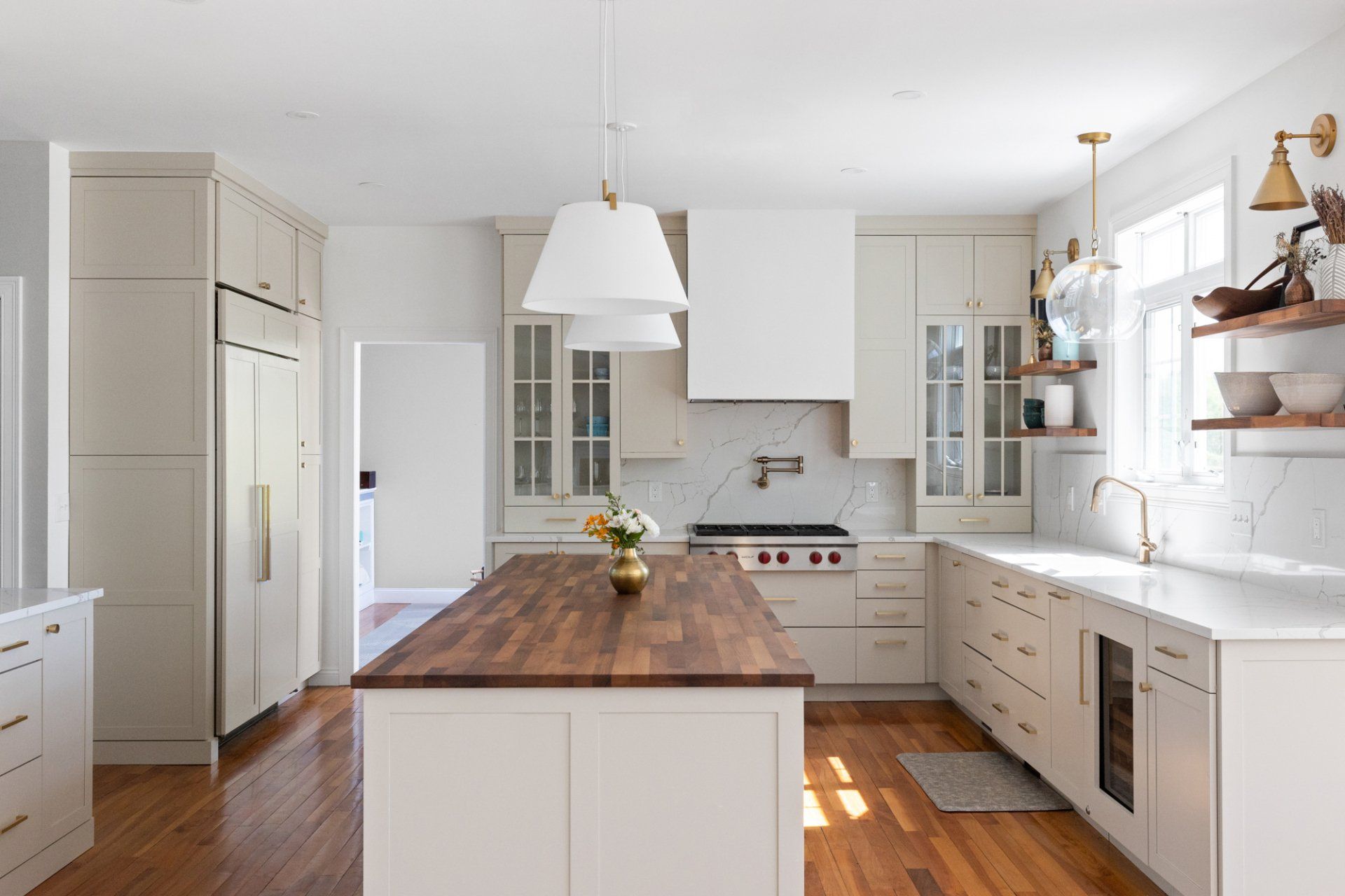 Bright white kitchen with wood island, stainless appliances, and open shelving