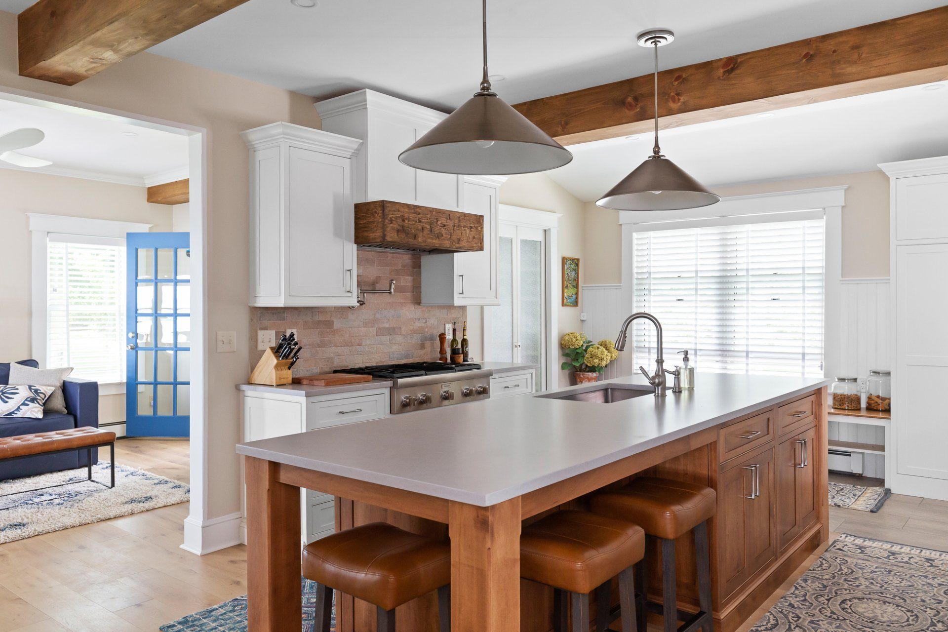 Bright modern kitchen with white cabinets, wood island, and pendant lights