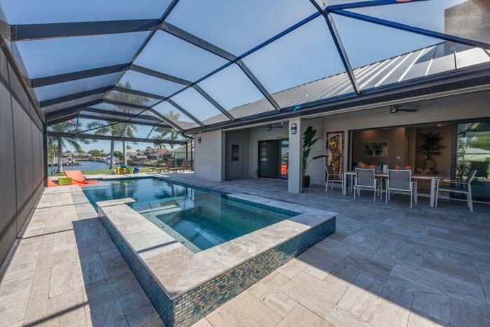 There is a large swimming pool in the backyard of a house.
