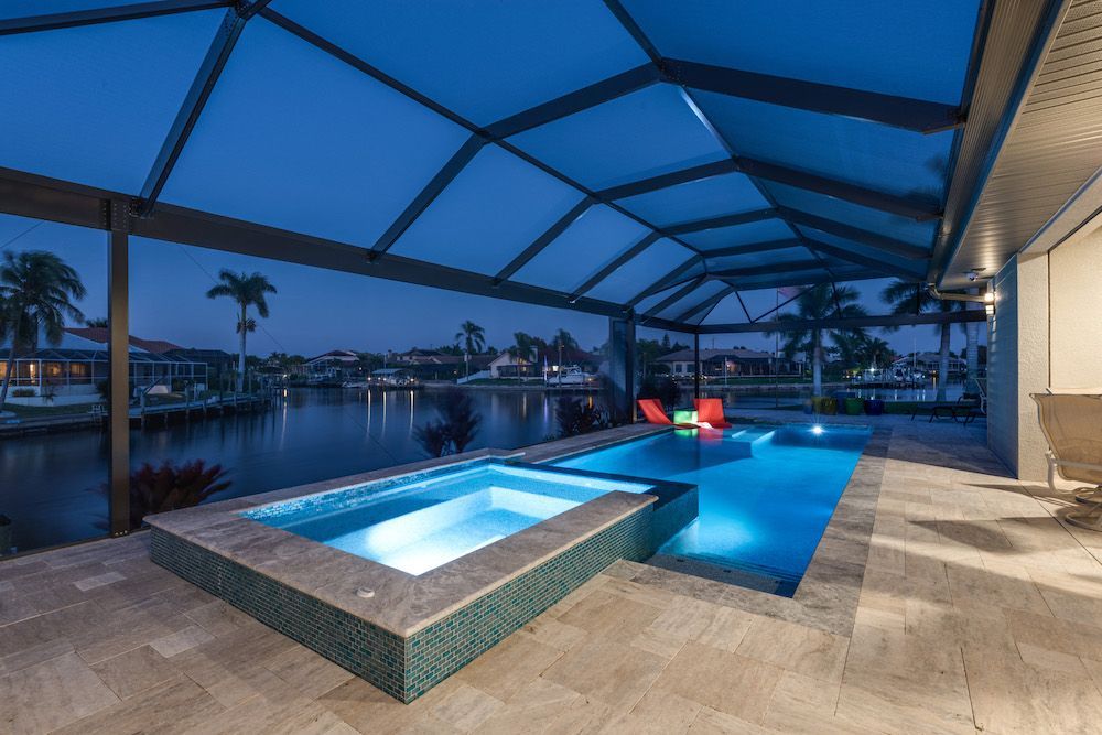 A large swimming pool with a hot tub underneath it