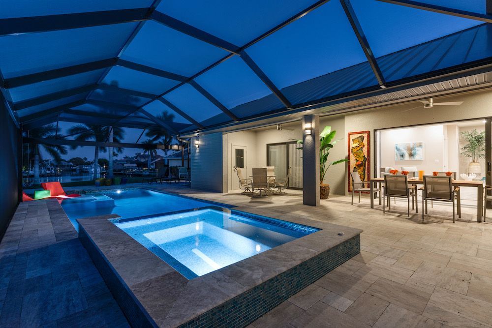 There is a large swimming pool in the backyard of a house.
