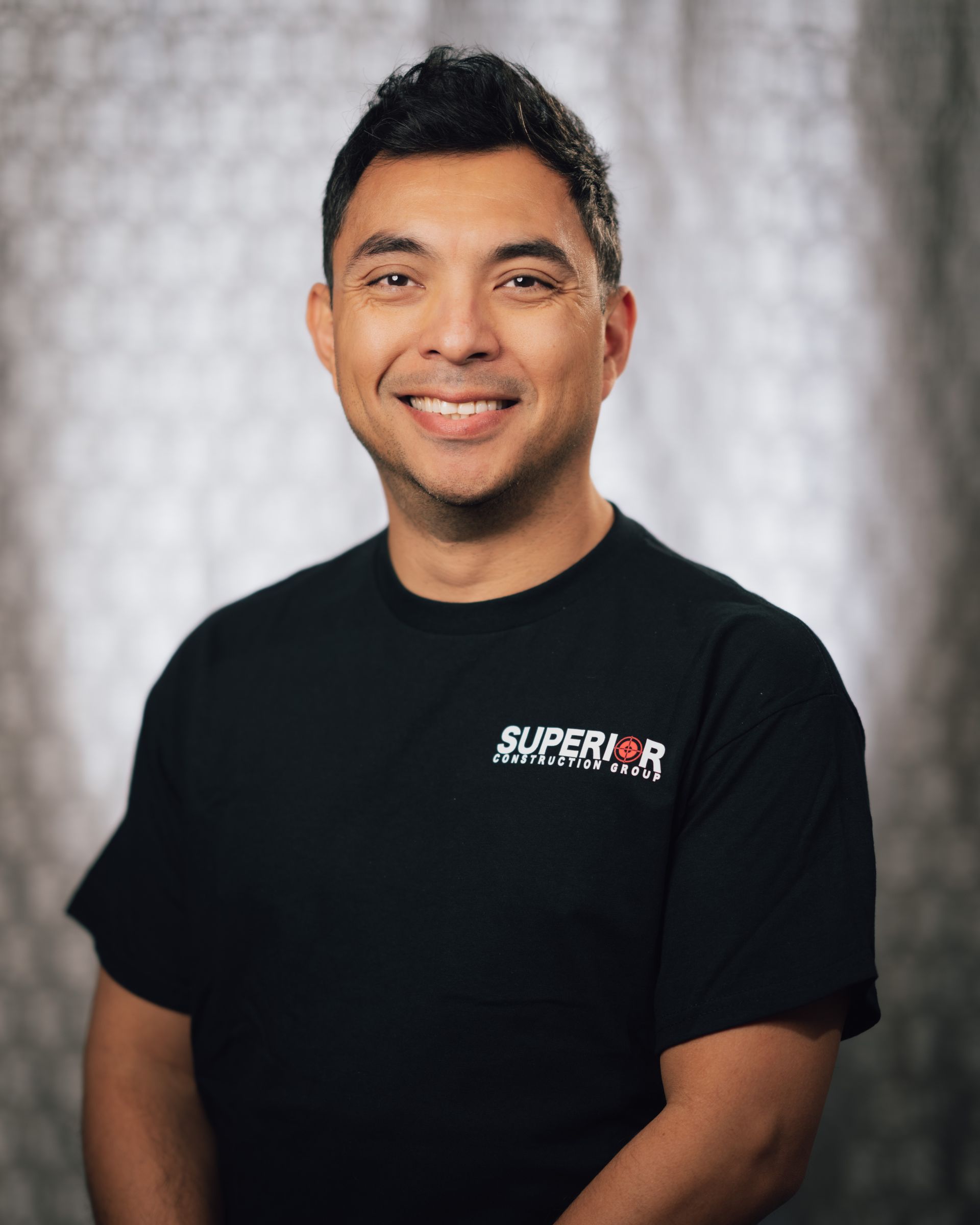 A man wearing a black shirt with the word superior on it