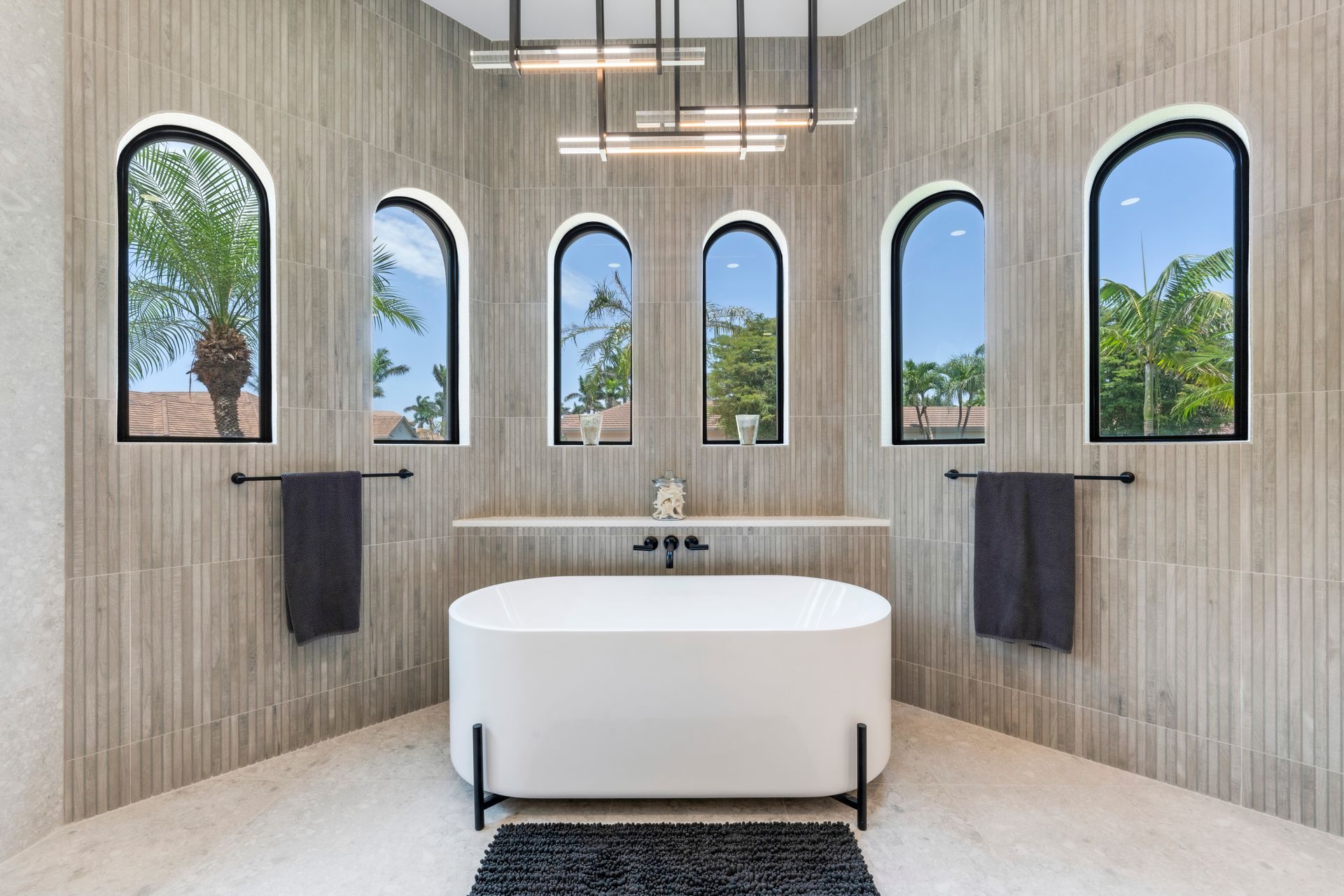 A bathroom with a bathtub and arched windows.