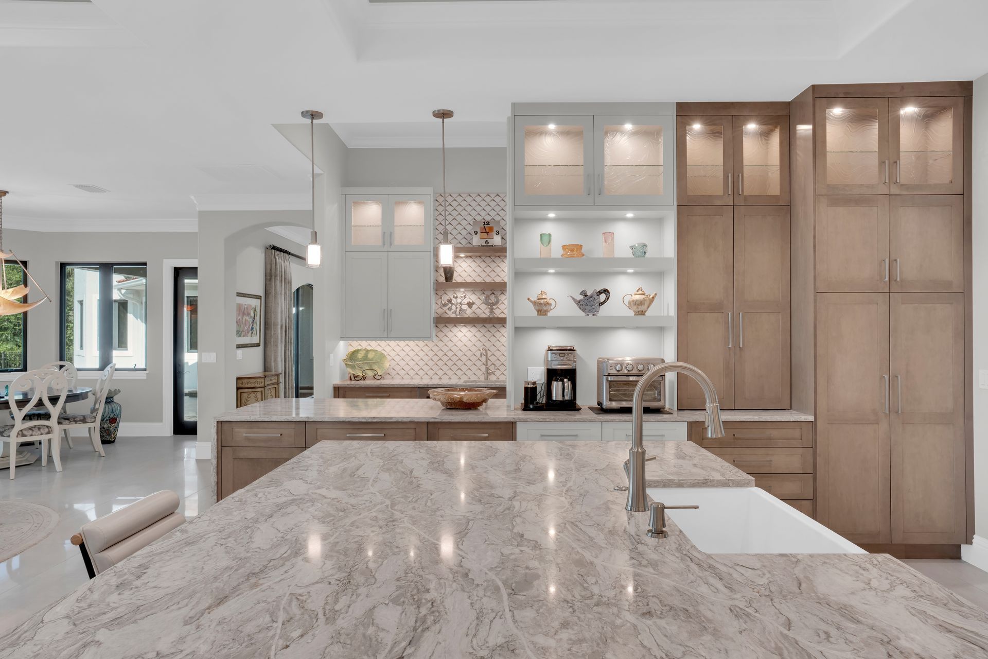Spacious kitchen with a large island and light-colored cabinetry; a built-in coffee station is visible.
