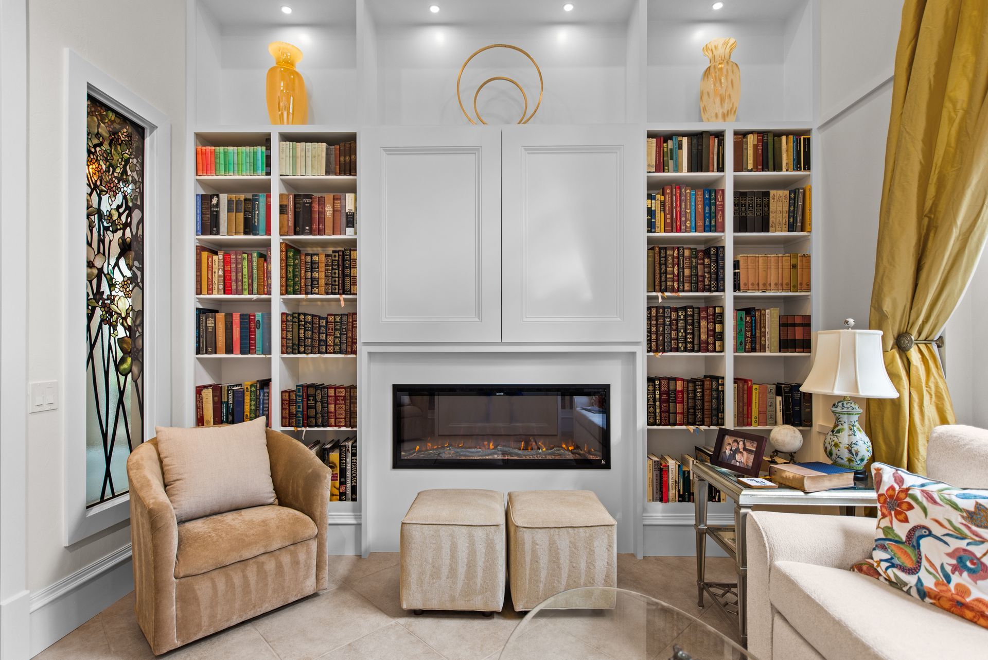 A living room with a fireplace and lots of bookshelves