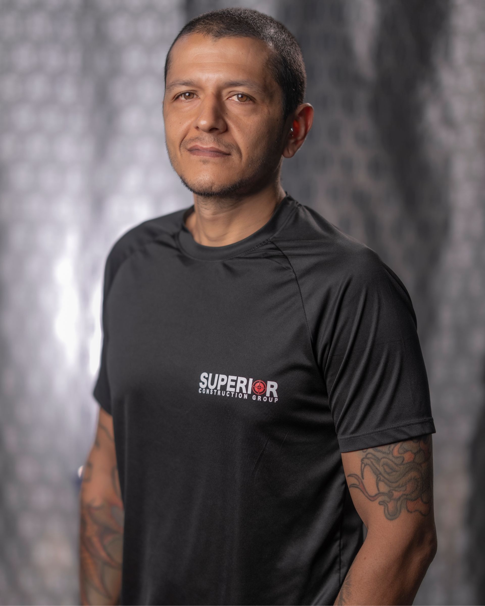 A man wearing a black shirt with the word superior on it