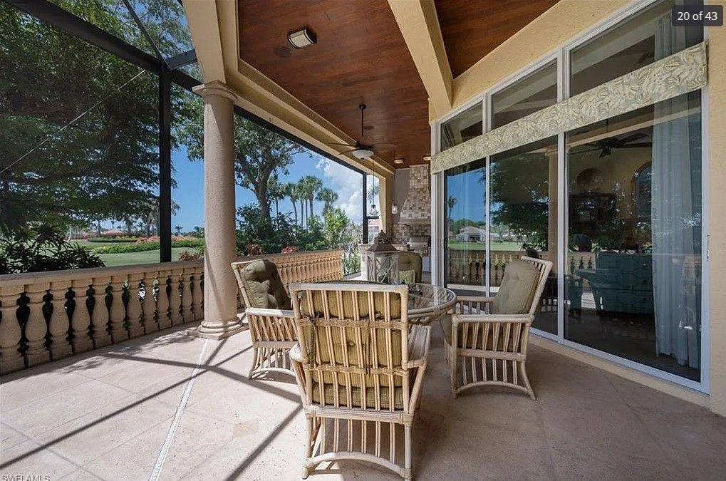 Covered patio with wicker furniture, overlooking a golf course.