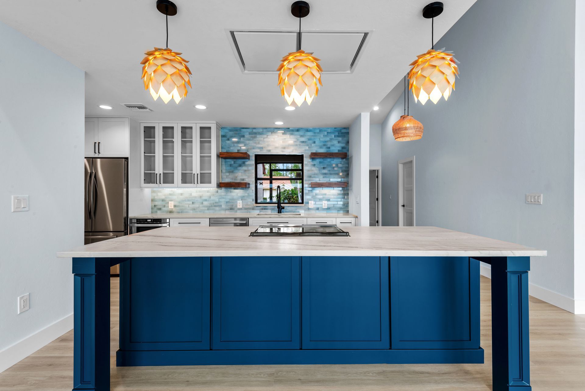 A kitchen with blue cabinets and a large island.